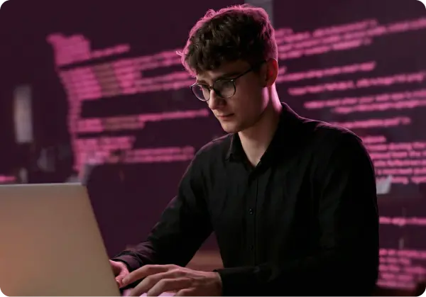 Homem usando o computador com códigos ao fundo