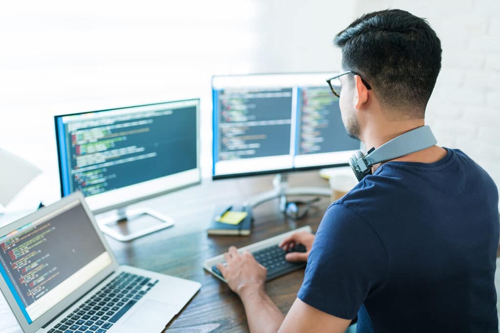 Pessoa com diversos computadores para aprender sql