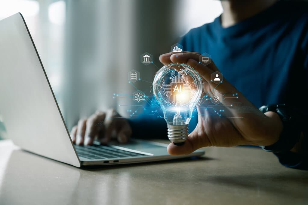 Pessoa trabalhando com notebook e uma lâmpada na mão simbolizando o que é rag