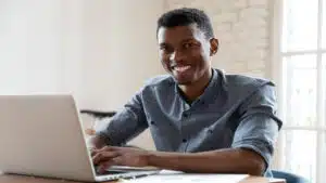 Profissional feliz no notebook porque aprendeu vue.js o que é