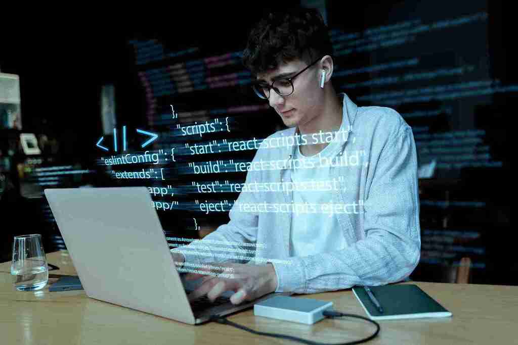 O que é Docker e por que você deveria aprender a usar essa ferramenta agora mesmo 8 Jovem programador trabalhando com códigos visíveis na tela, simbolizando o conceito de o que é Docker