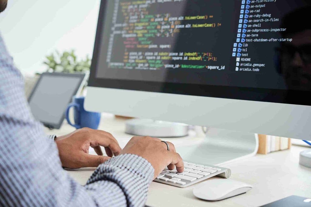 programador escrevendo códigos no computador, representando o Gemini Code Assist